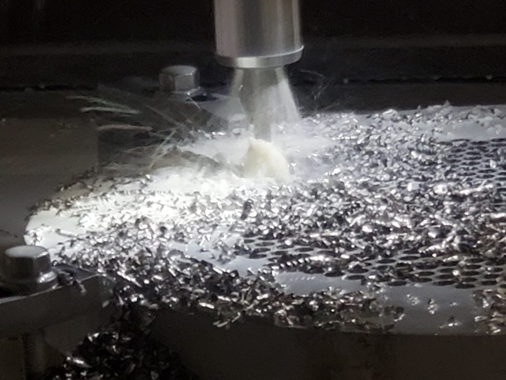 CNC machining of a heat exchanger tubesheet with coolant and metal chips