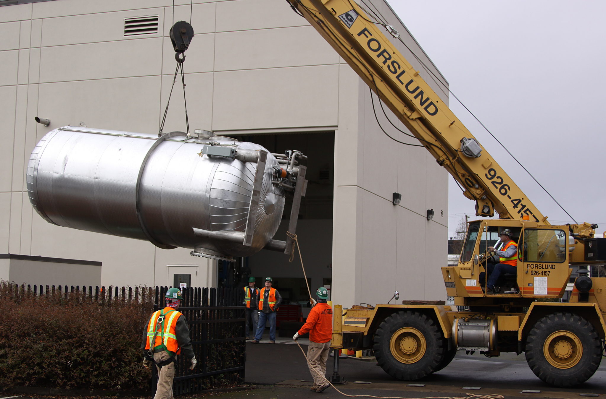 The top deck of a large fabricated tank staged at a waterfront facility